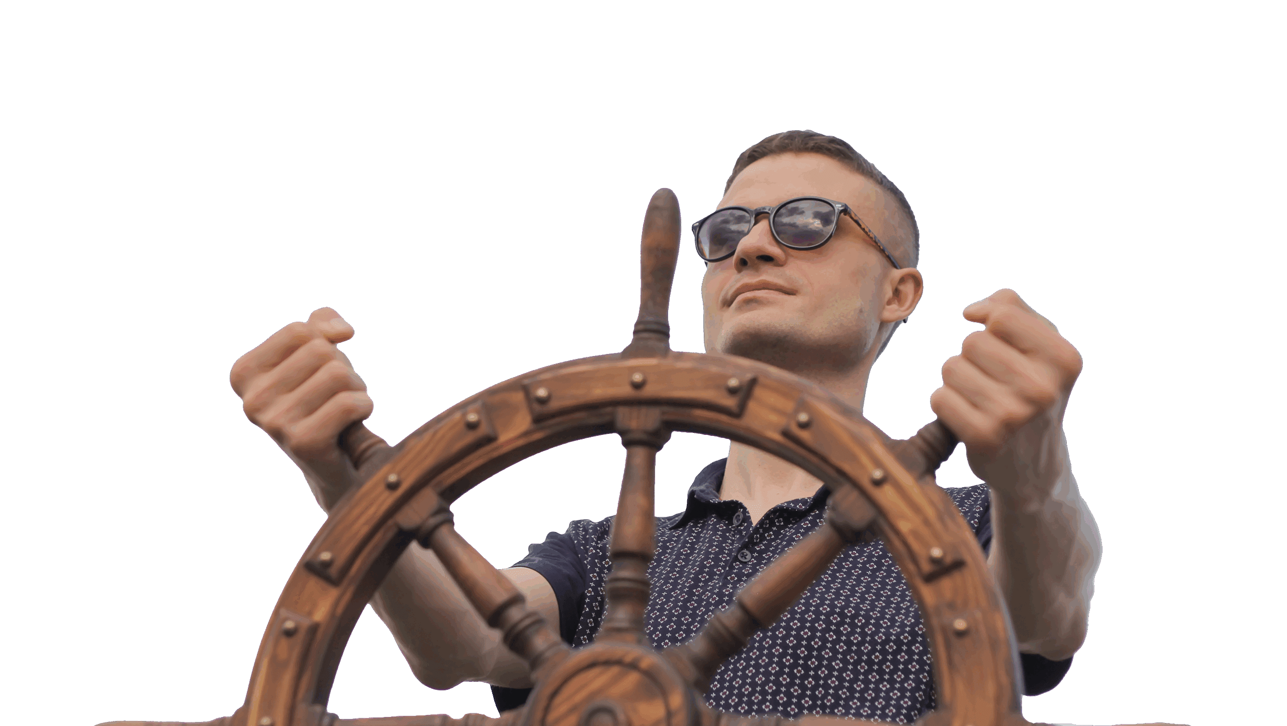 A man in sunglasses grips a steering wheel while driving